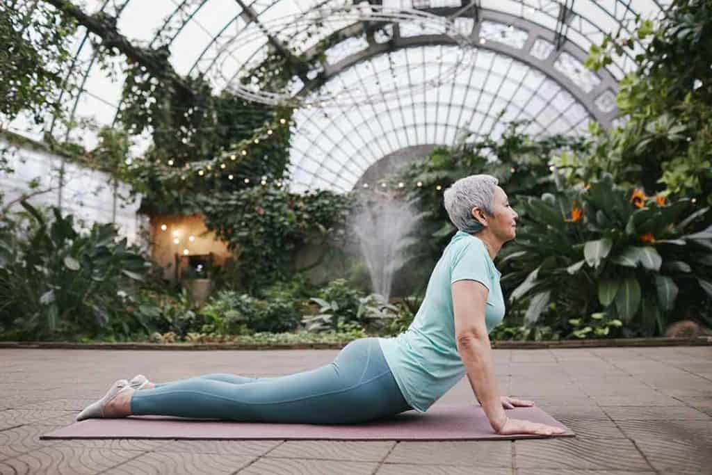 Older woman doing yoga for sciatica in cobra pose